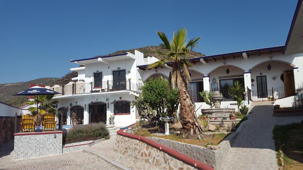 Santa Rosa de JáureguiLa Casona Azul Bed n Breakfast的前面有棕榈树的白色房子
