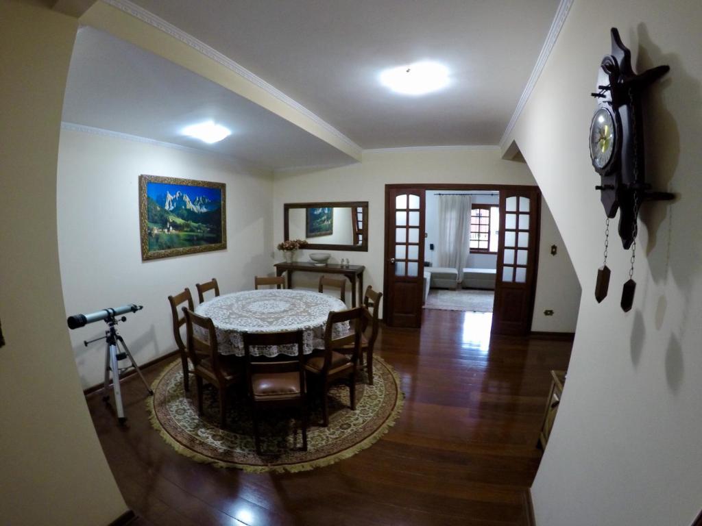 波苏斯-迪卡尔达斯Confortável casa de madeira的一间带桌椅和时钟的用餐室