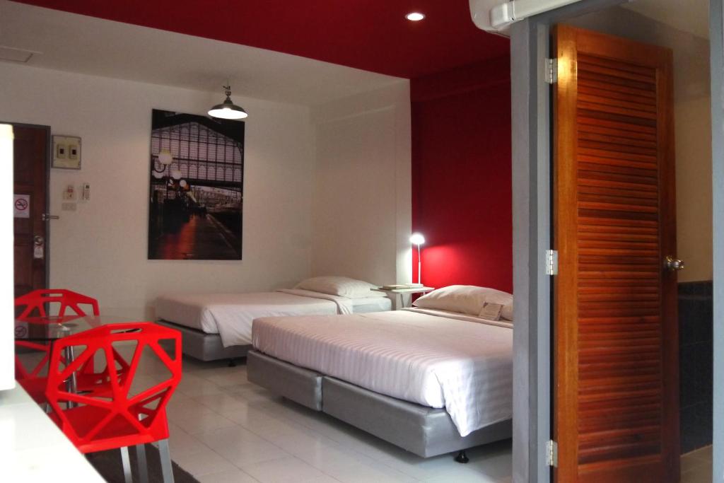 Thung Song童颂@希诺酒店的红色调的客房内的两张床