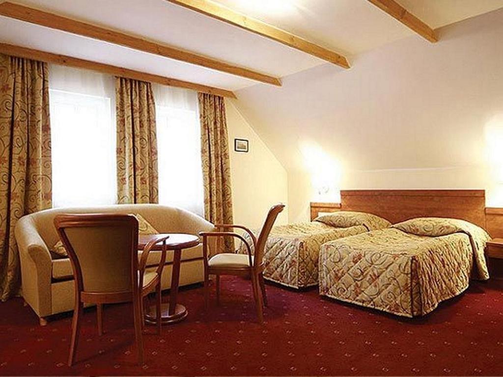 埃尔布隆格M.F.宾馆的酒店客房带两张床和一张桌子以及椅子。