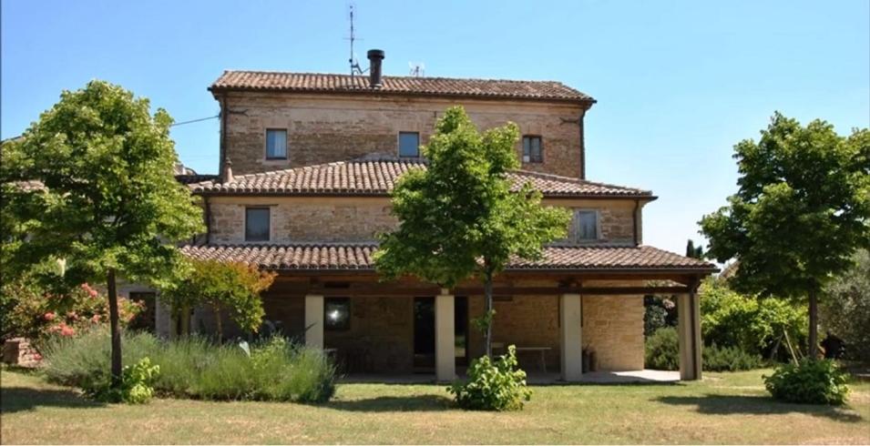 MoieStone farmhouse in Moie的前面有树木的大型砖房