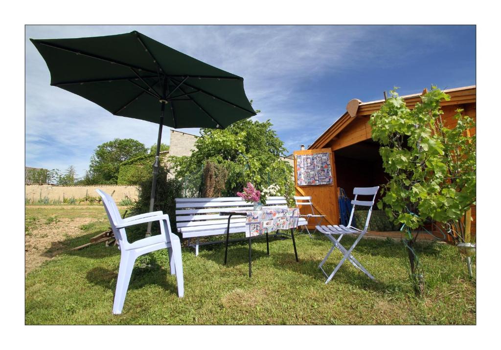 Sainte-Croixgîte la grange的草丛中的桌椅和雨伞
