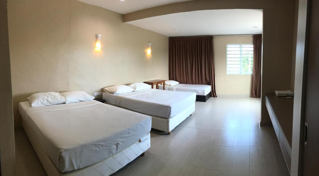 关丹Pantai GuestHouse的酒店客房设有两张床和一张桌子。