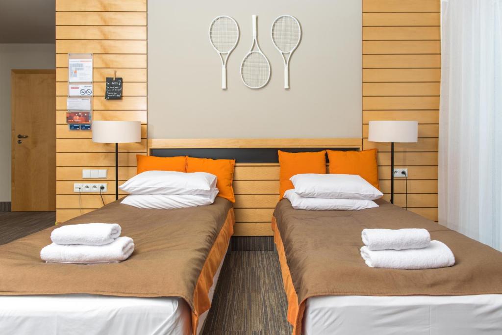 波兹南Hotel Restauracja Tenis Kortowo的客房内的两张床和毛巾