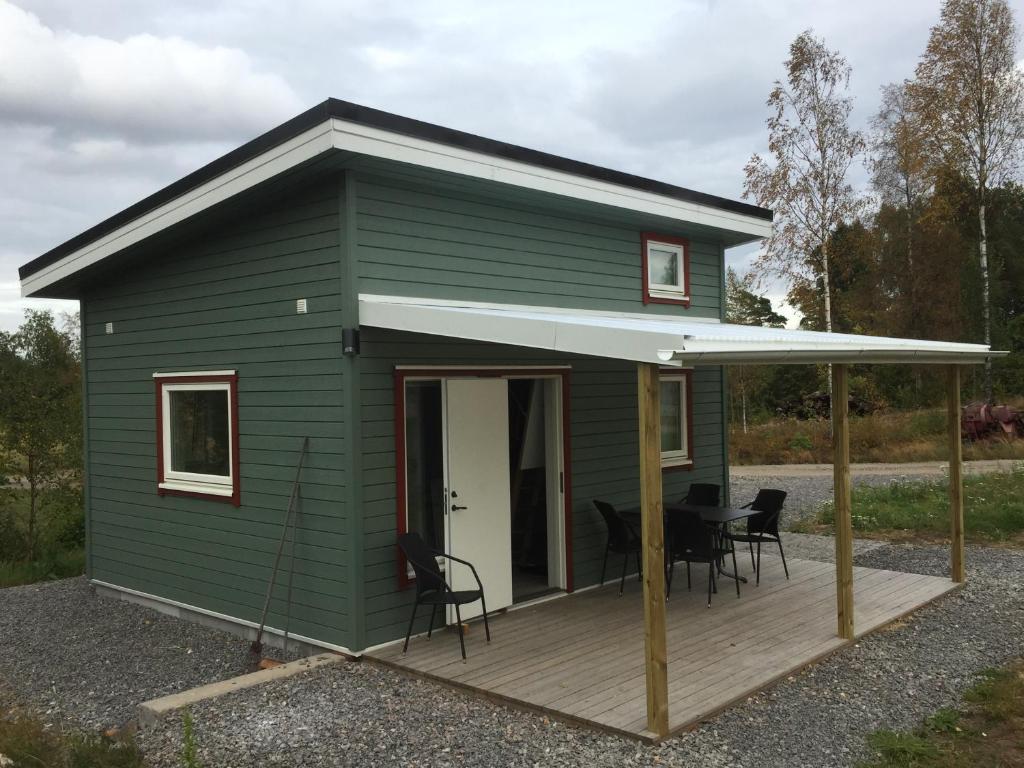 特罗尔海坦Larstorpsvägen 12的绿色的小房子,设有木甲板