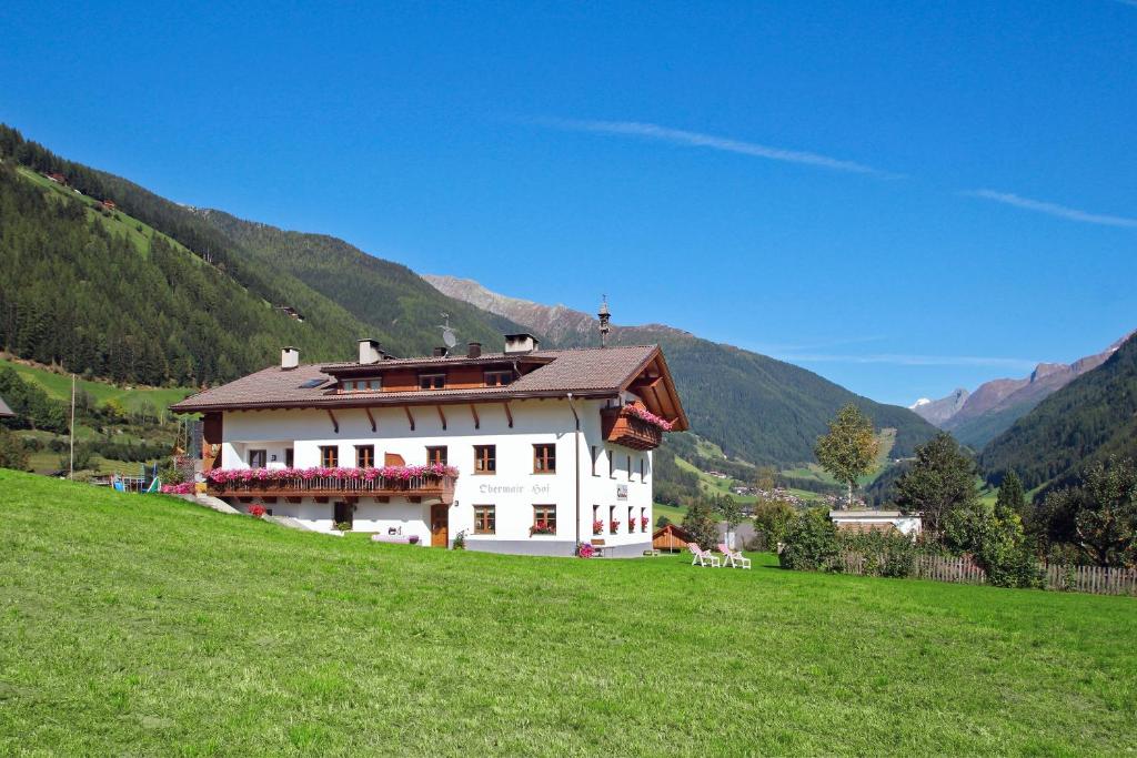 圣贾科莫Obermairhof的绿色田野上山丘上的白色房子