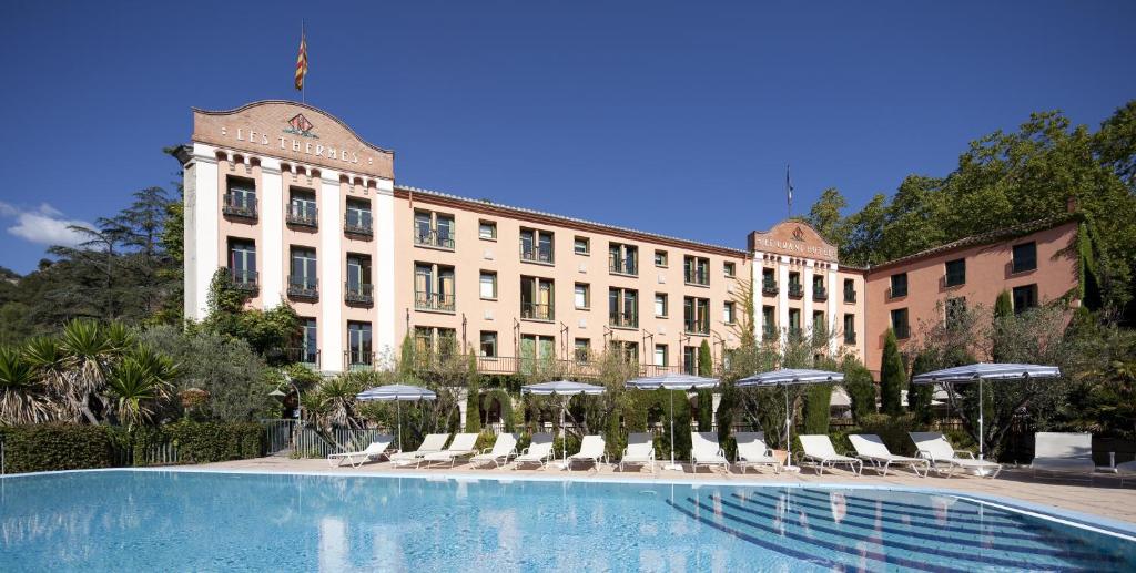 莫利大酒店的一座带游泳池、椅子和遮阳伞的大型建筑