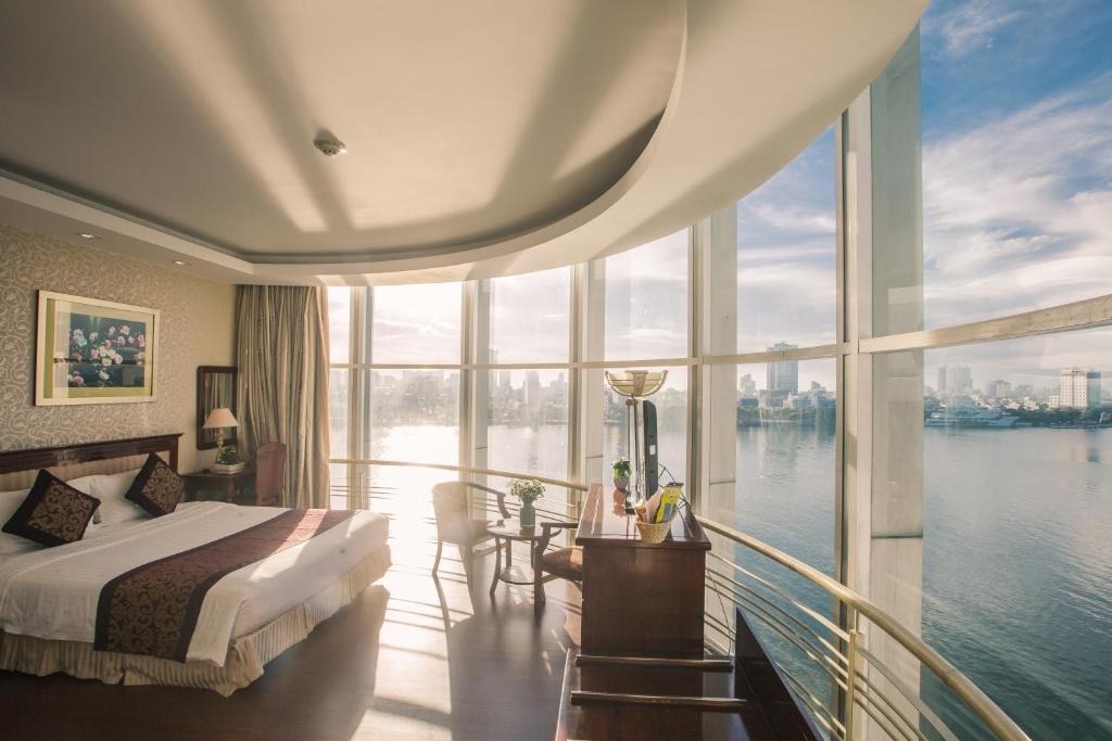 岘港太阳河酒店的一间卧室配有一张床和一个享有水景的阳台