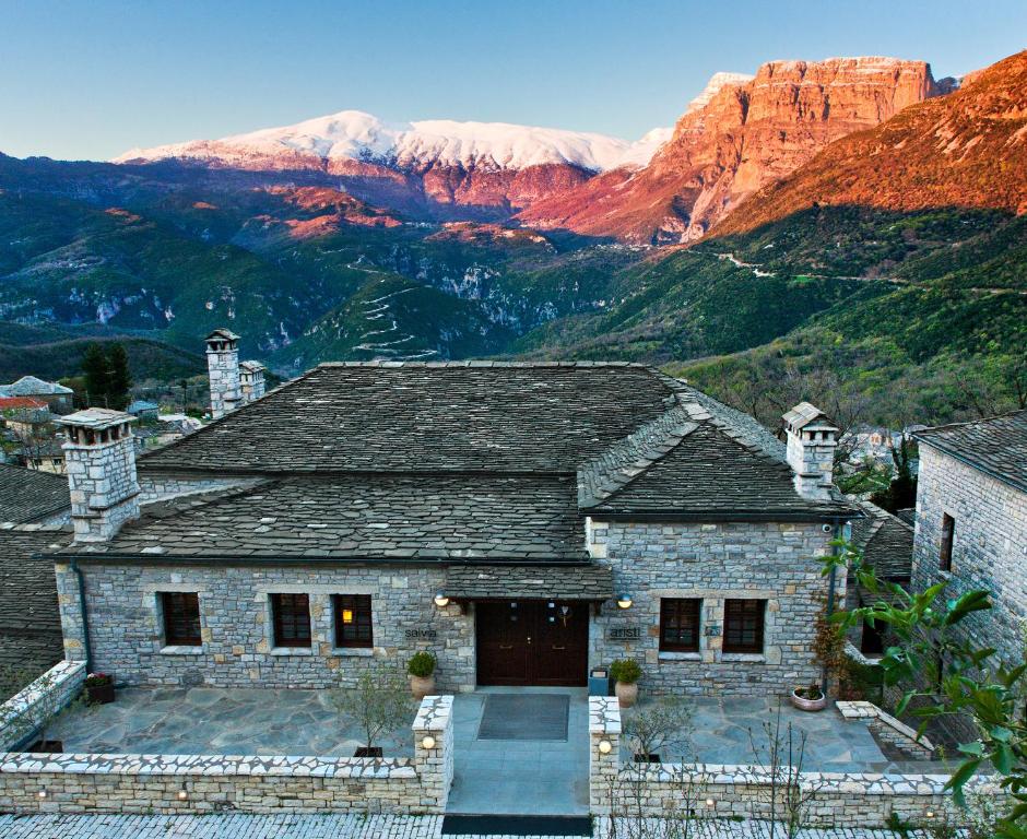 阿里斯蒂阿里斯缇山区度假酒店的一座以山为背景的石头房子