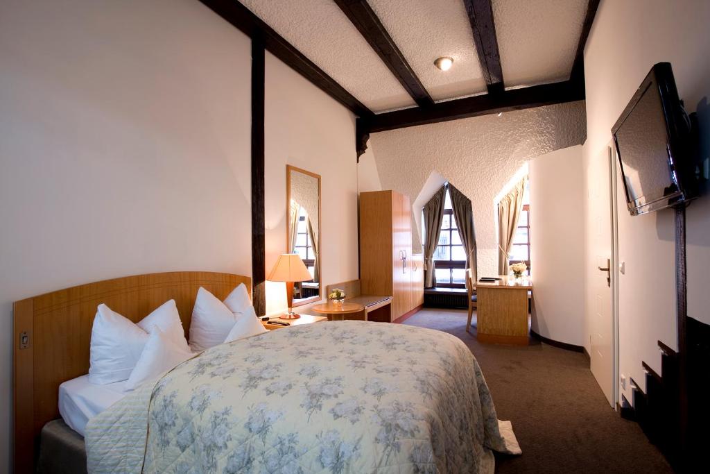 斯图加特特劳贝酒店的一间卧室配有一张床和一台电视。