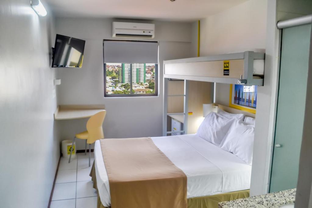 马塞约R1快捷酒店的一间医院间,配有床和电视