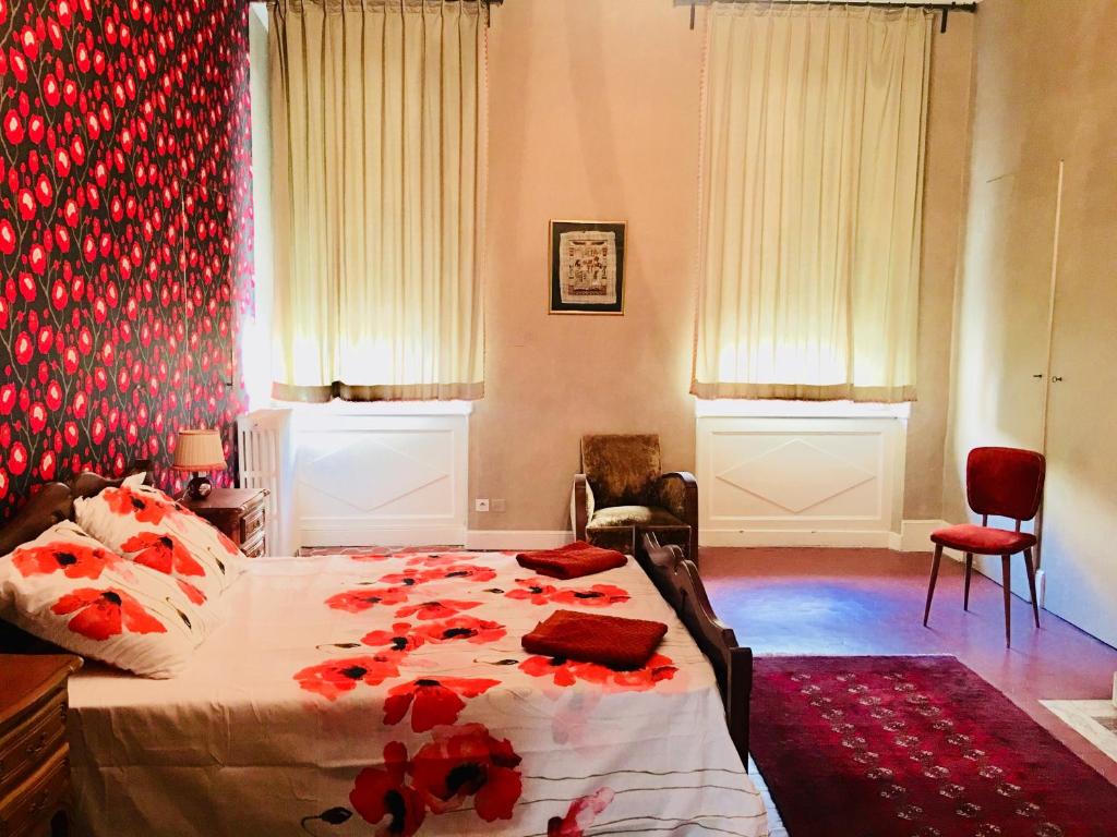 纳博讷Les Chambres des Barques的一间卧室,床上有红色的鲜花