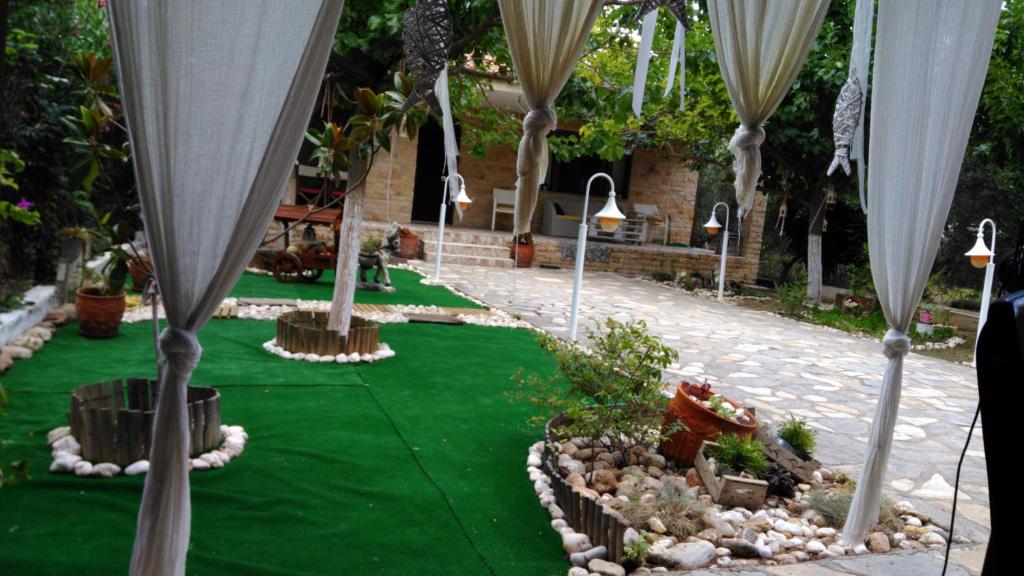 尼坡帝ATHINA'S HOUSE的一个带绿草和白色遮阳伞的花园