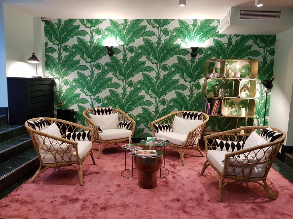 日内瓦派克斯酒店的一间设有椅子、桌子和壁纸的等候室
