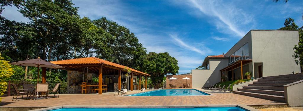 蒂拉登特斯Pousada Recanto das Araras的一座带游泳池和庭院的房子
