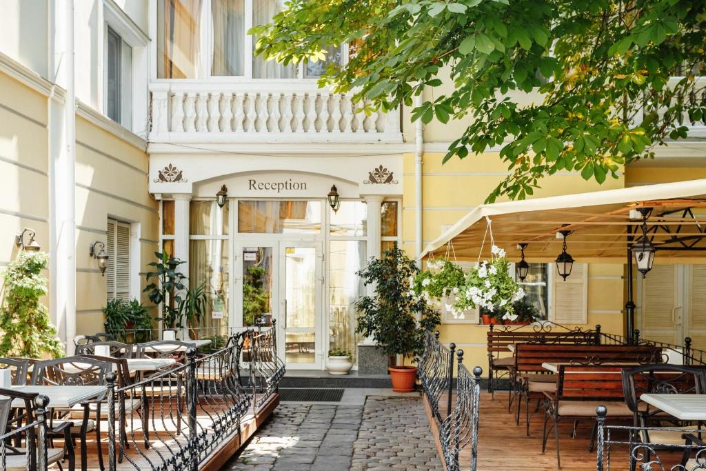 敖德萨Residence Odesskij Dvorik的大楼前设有桌椅的餐厅