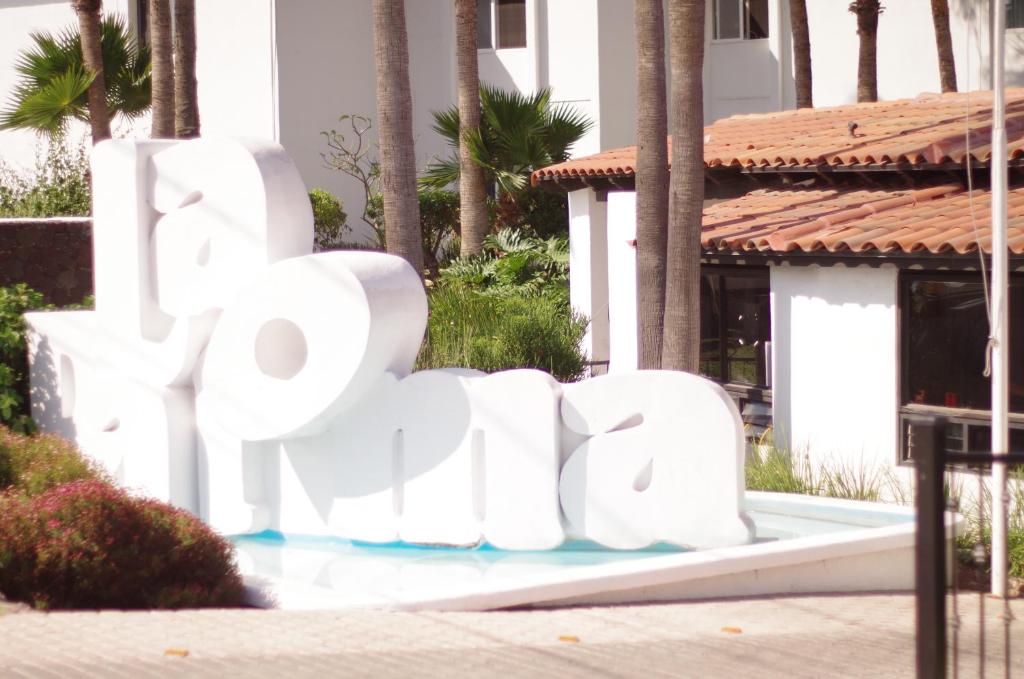 罗萨里托La Paloma Beach&Tennis Resort的建筑前的一个白色大标志