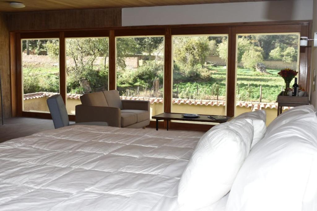 奥兰太坦波Casafranca的卧室设有白色的床和大窗户