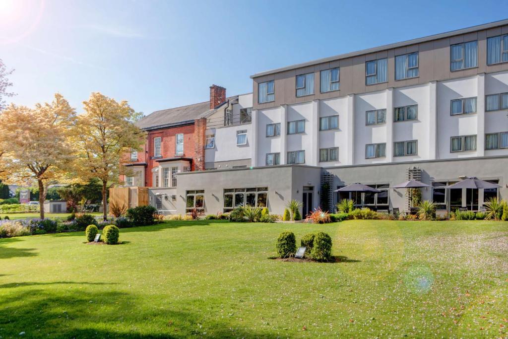 汉德福斯Best Western Plus Pinewood Manchester Airport-Wilmslow Hotel的前面有草坪的大建筑