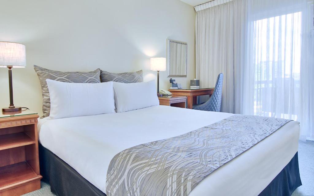 布里斯班布里斯班Soho酒店的配有一张床、一张书桌和一扇窗户的酒店客房