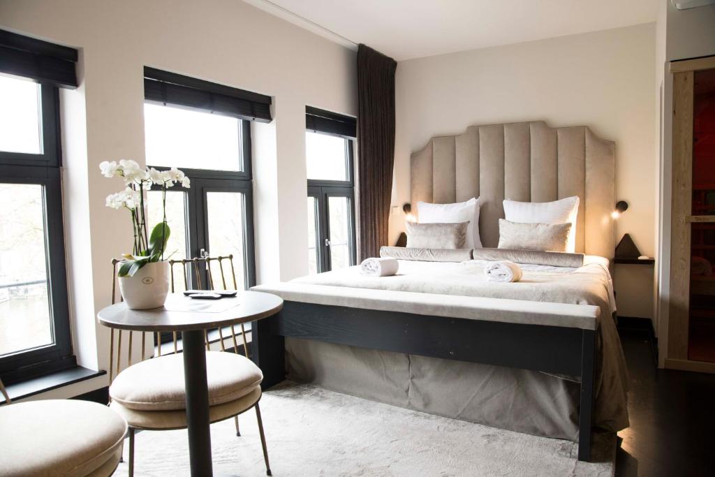 阿姆斯特丹阿姆斯特尔豪斯酒店的一间卧室配有一张大床和一张桌子