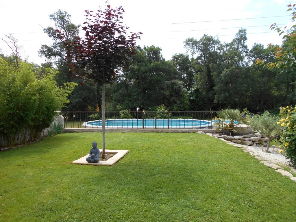 圣萨蒂南艾普特chez lulu的一座花园,花园内种有树木,并设有一个游泳池