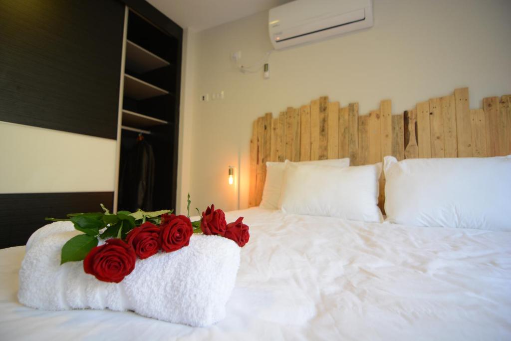 耶鲁姆Luna BaNeguev的一张白色的床,上面有红玫瑰