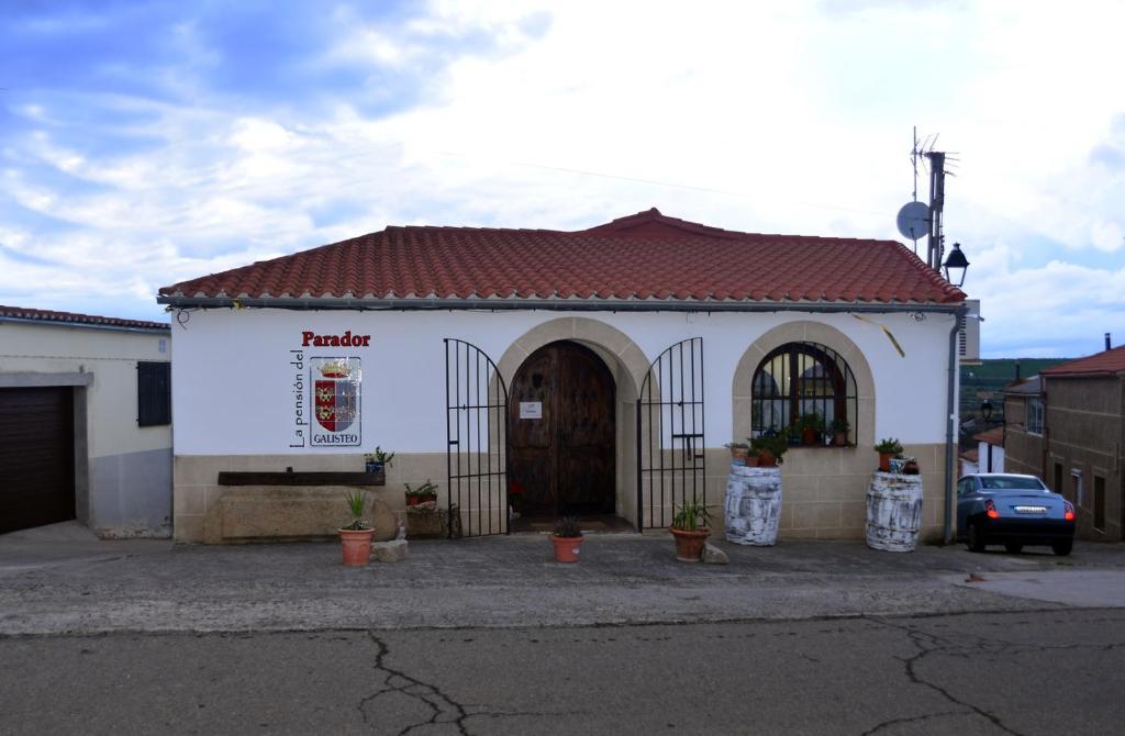 GalisteoLa pension del Parador的白色的小建筑,带有棕色的屋顶