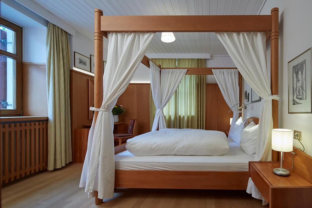 圣坎迪朵克里斯蒂娜别墅酒店的卧室配有带白色床单的天蓬床