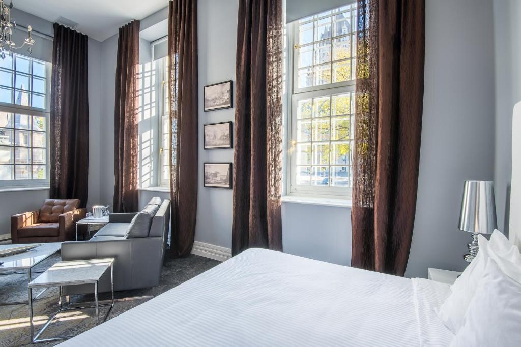 魁北克市摩根庄园酒店的一间卧室配有一张床、一把椅子和窗户。