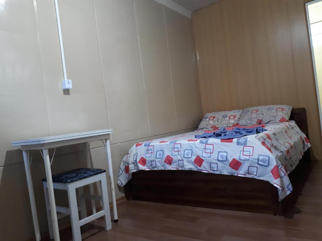 纳韦甘蒂斯Suíte Barros的一间小卧室,配有一张床和一张桌子