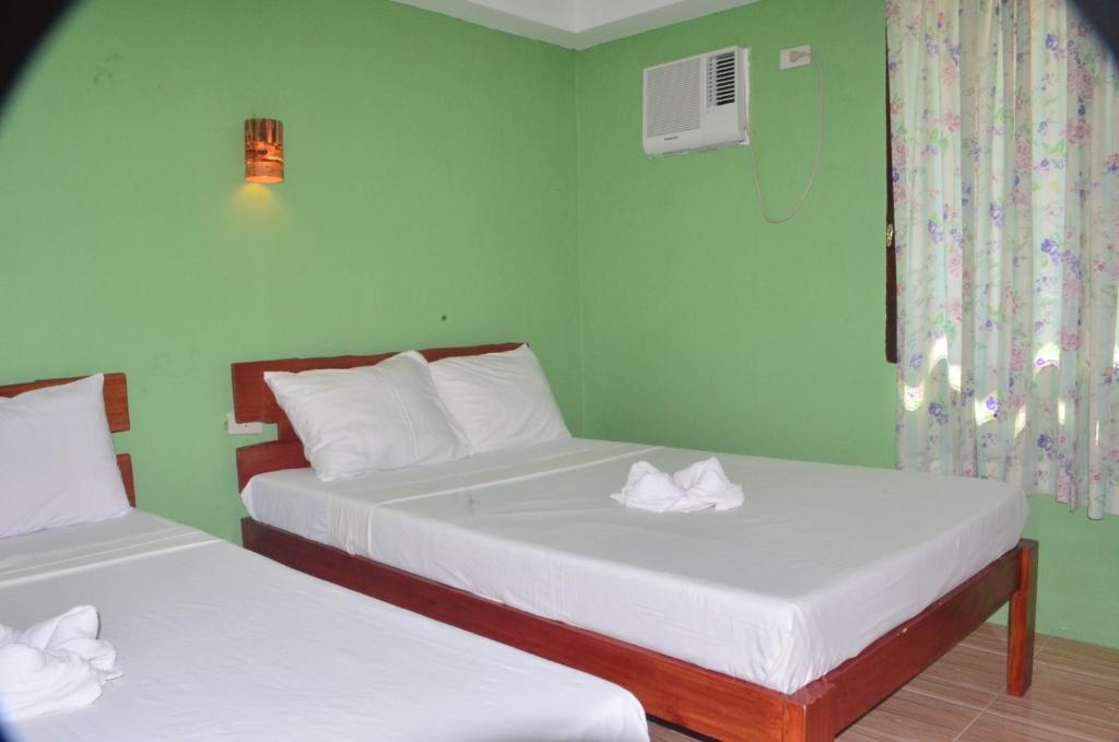 班塔延岛斯夫坎提纳旅馆的绿墙客房内的两张床