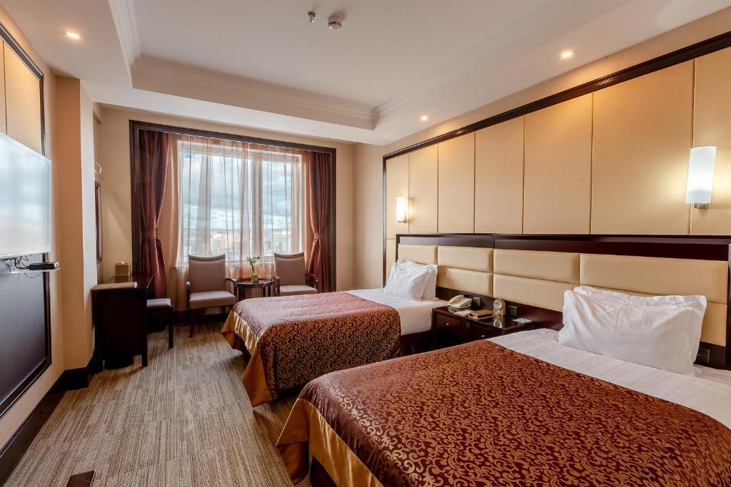 乌兰巴托乌兰巴托格兰德希尔酒店的酒店客房设有两张床和一台平面电视。