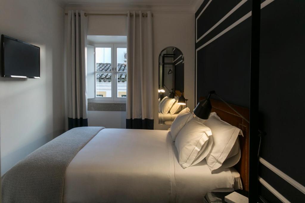 埃武拉Valeriana Exclusive GuestHouse的一间卧室配有一张大床和镜子