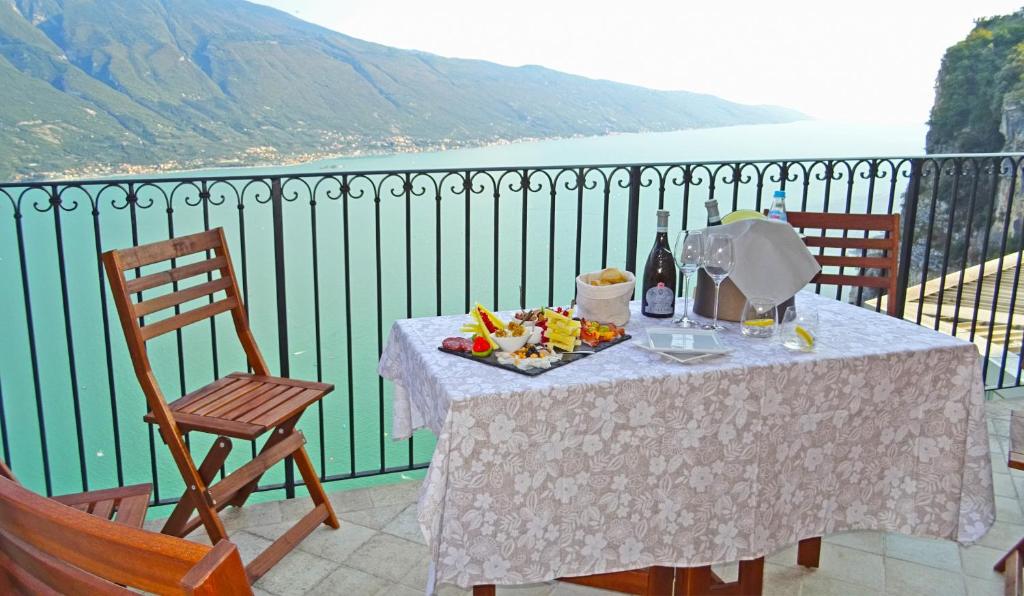 特雷莫西内Casa De Pol Exclusive Lake View by Gardadomusmea的阳台上的餐桌上放着一盘食物