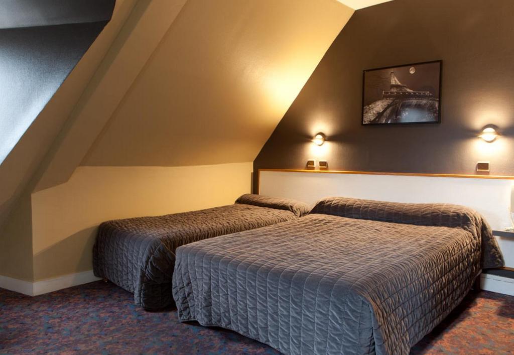 巴黎格兰德酒店的一间酒店客房,房间内设有两张床