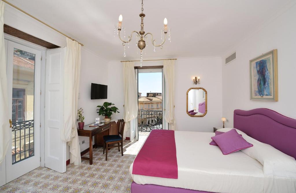 阿马尔菲卢斯公寓的配有一张床、一张书桌和一扇窗户的酒店客房