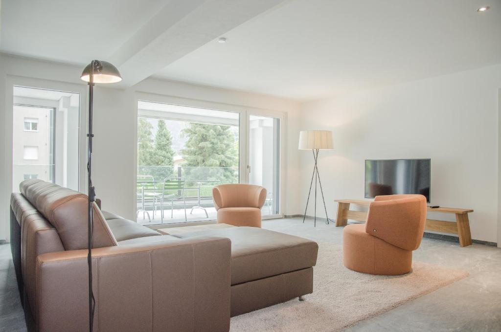 因特拉肯Apartment JungfrauCenter Schynige Platte - GriwaRent AG的客厅配有沙发和两把椅子