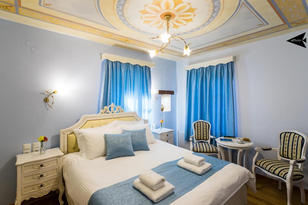 切佩洛沃帕罗拉亚别墅旅馆的一间卧室配有一张带蓝色窗帘的大床