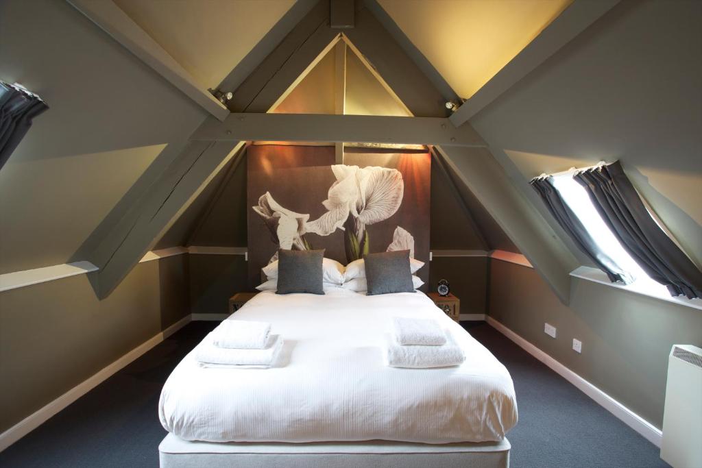 迪德马顿金斯阿姆酒店的阁楼卧室配有一张白色大床