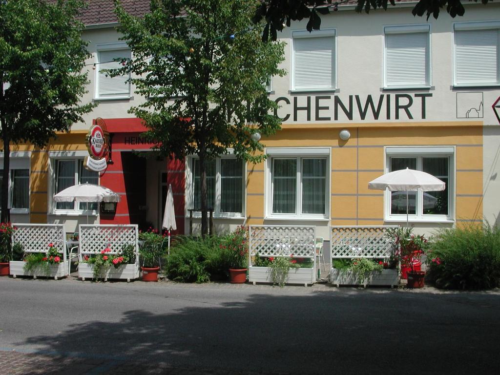 德意志克罗伊茨Kirchenwirt Heinrich Gasthof的大楼前有长椅的餐厅