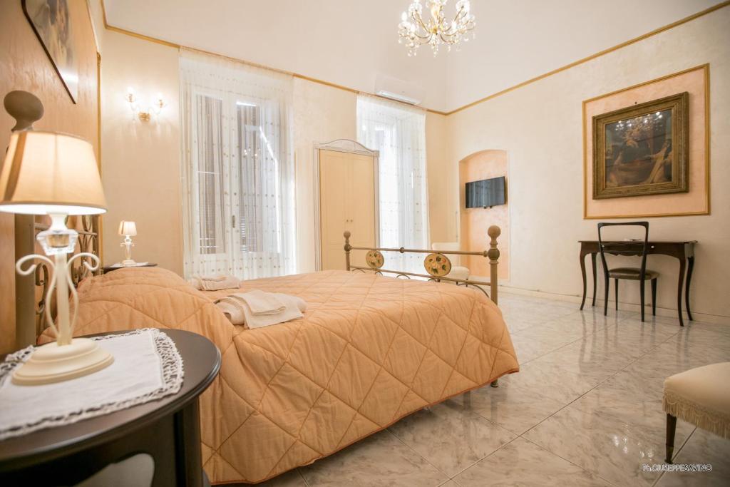 Palo del ColleB&B Nonna Lella的一间卧室配有一张床、一张桌子和一张桌子。
