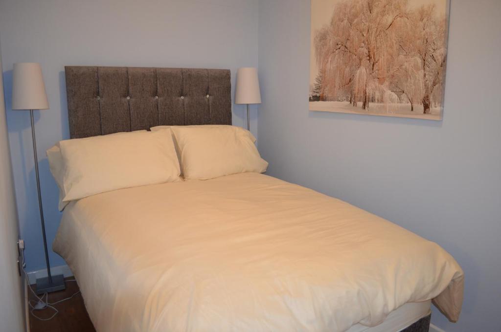 水上伯顿Roman Villa的一间卧室配有一张带白色床单和两盏灯的床。