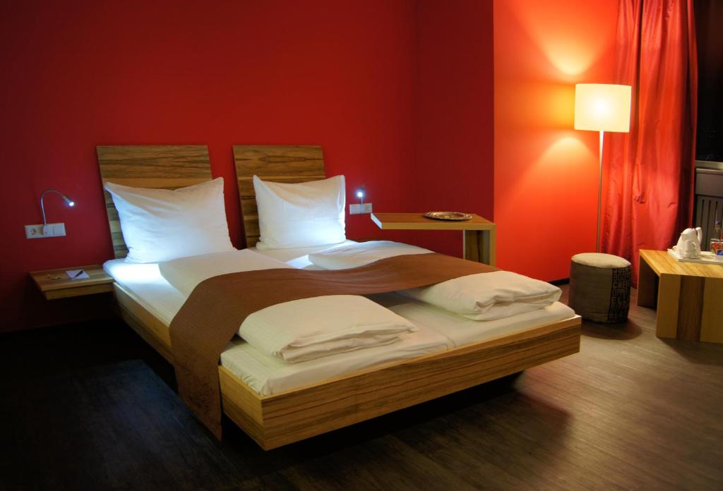 菲尔德施塔特斯图加特梅斯AMH酒店机场店的一间卧室设有一张带红色墙壁的大床