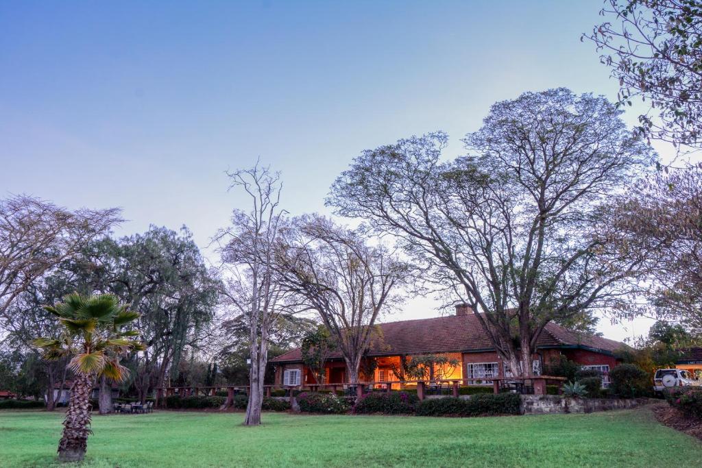 Gilgil伊莱门蒂塔雅卡兰达拉克山林小屋的一座树木繁茂的院子中的房子