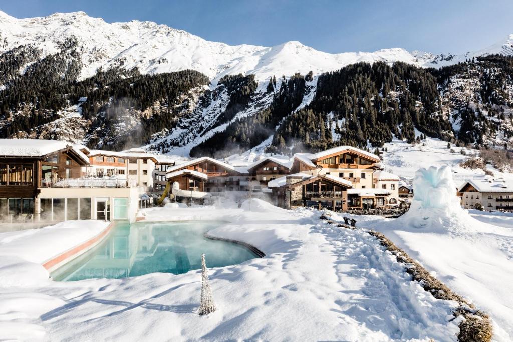 丽丹纳施内贝格家庭Spa及度假酒店的雪地中带游泳池的度假村