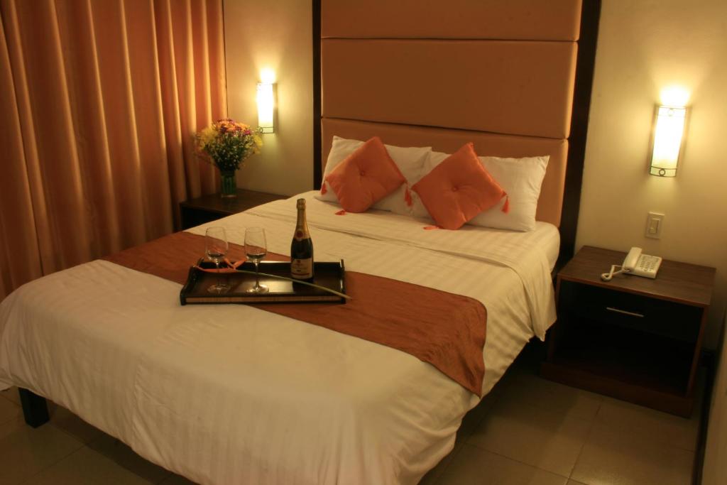巴科洛德O Hotel的酒店的客房 - 带一张床和一个带瓶子及眼镜的托盘