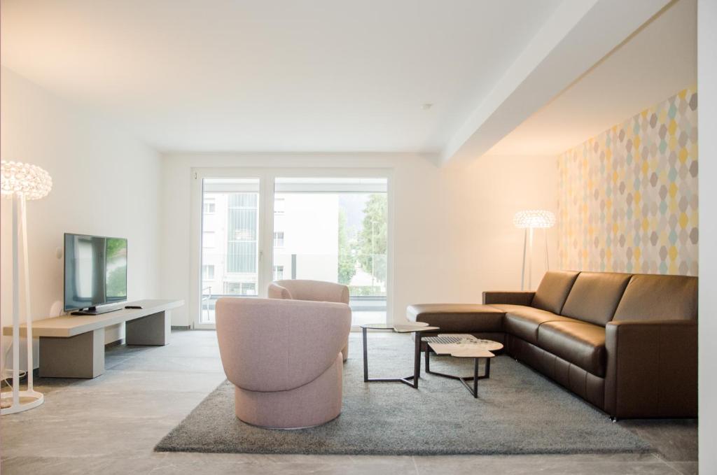 因特拉肯Apartment JungfrauCenter Bällenhöchst - GriwaRent AG的带沙发和电视的客厅
