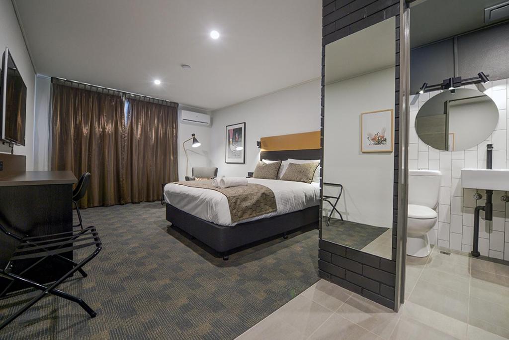 科夫斯港CBD Motor Inn的一间酒店客房 - 带一张床和一间浴室