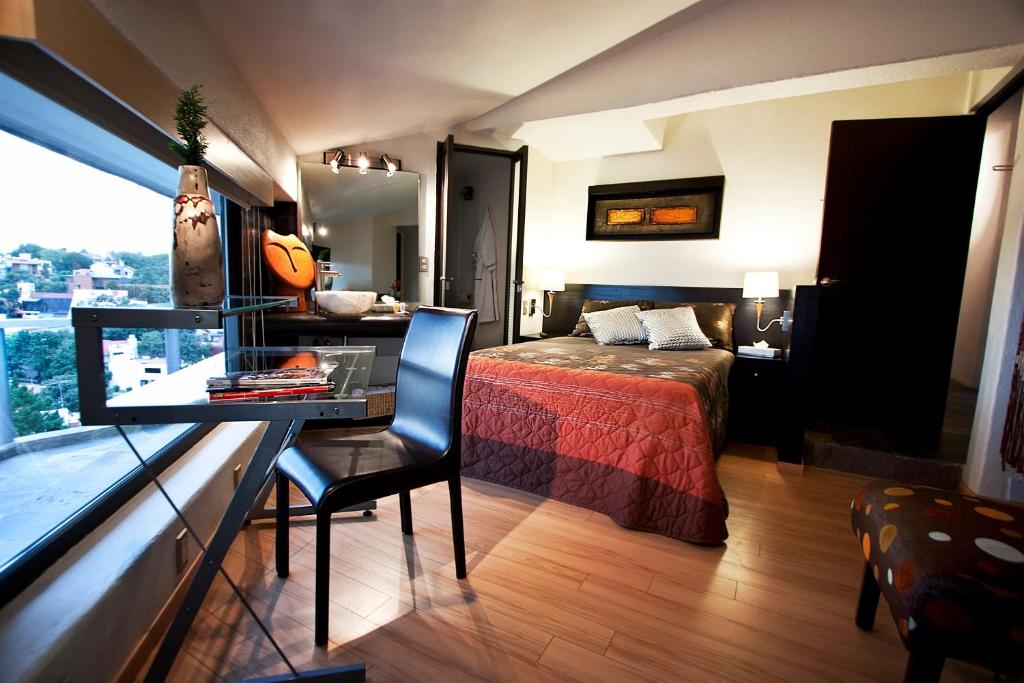墨西哥城阿兹蒂行政套房酒店的一间酒店客房,配有一张床和一张书桌